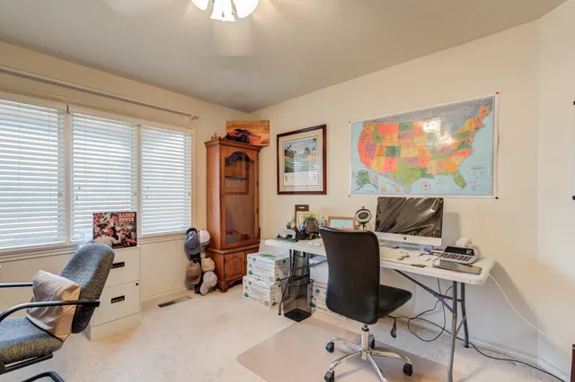 a view of a workspace with furniture and a window
