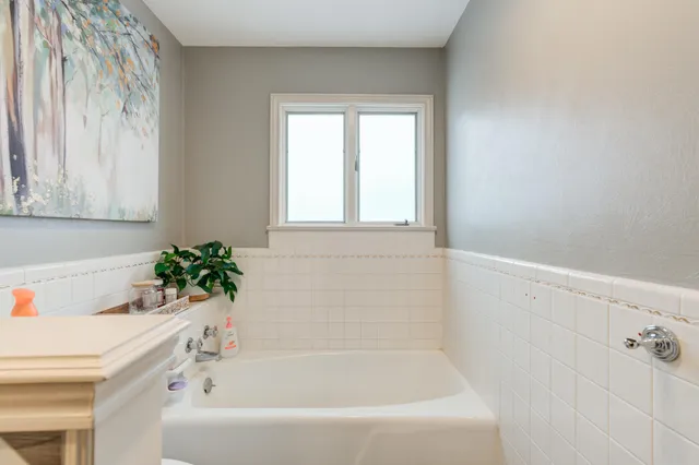 a white bath tub sitting next to a white cabinet