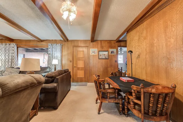 a living room with furniture a chandelier and a large window