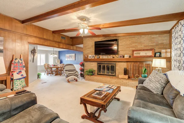 a living room with furniture a flat screen tv and a fireplace