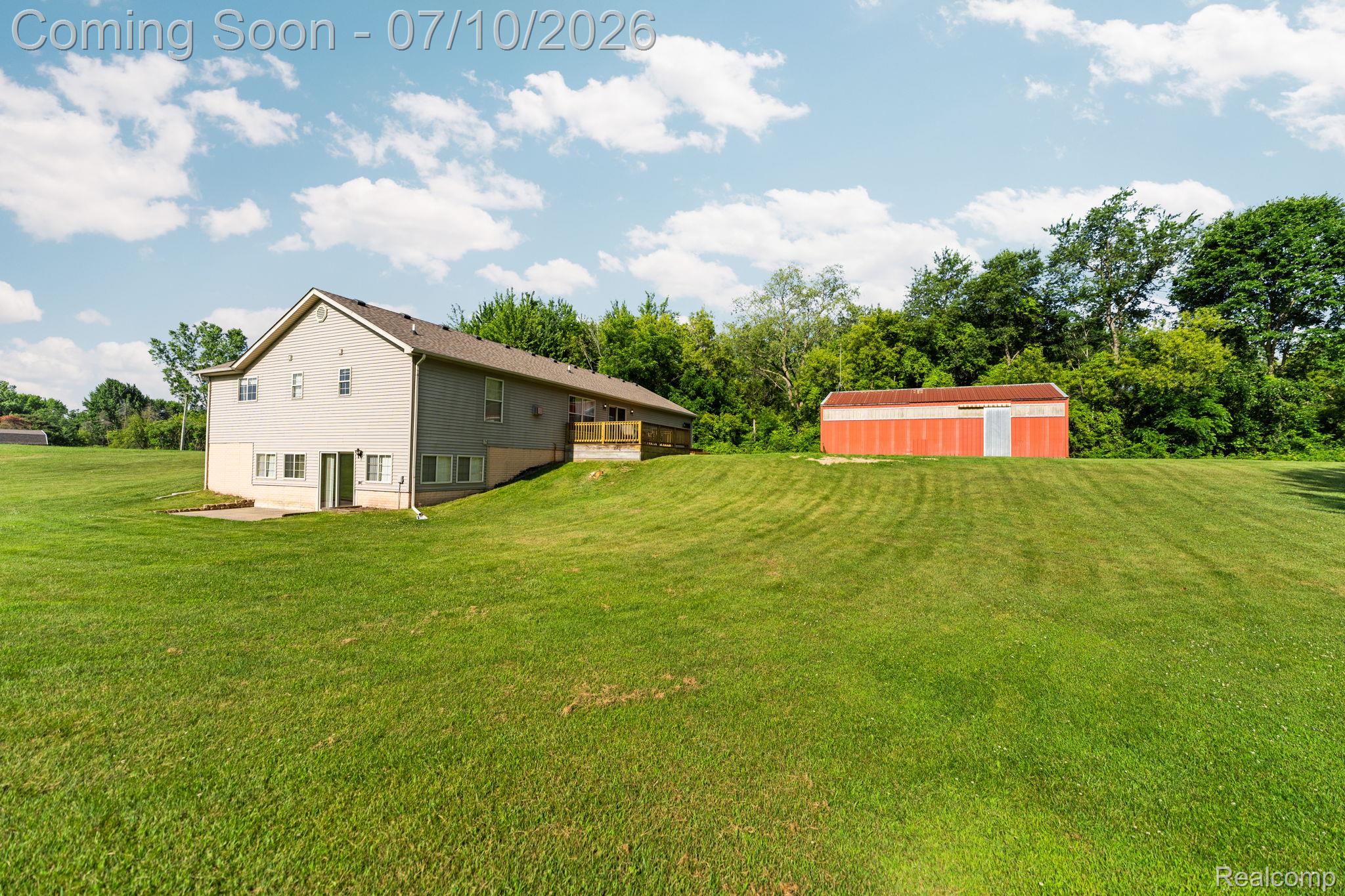 3144 North Nicholson Road Fowlerville, MI 48836 - Photo 23 of 70 Expansive green lawn surrounding a two-story residence with a walk-out lower level and a wooden deck