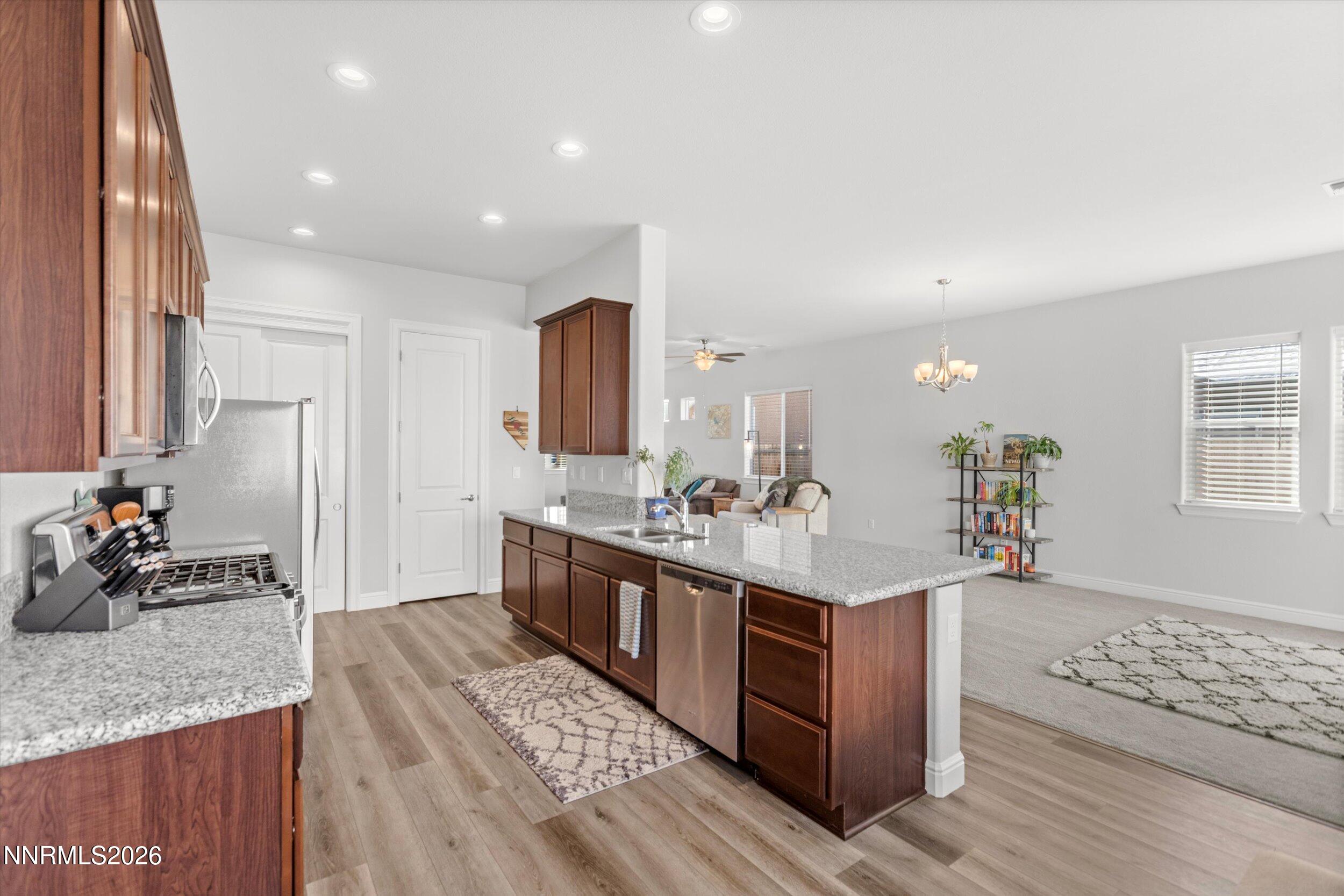 11125 Gallaudet Drive Reno, NV 89506 - Photo 11 of 32 a kitchen with stainless steel appliances granite countertop a sink stove and cabinets