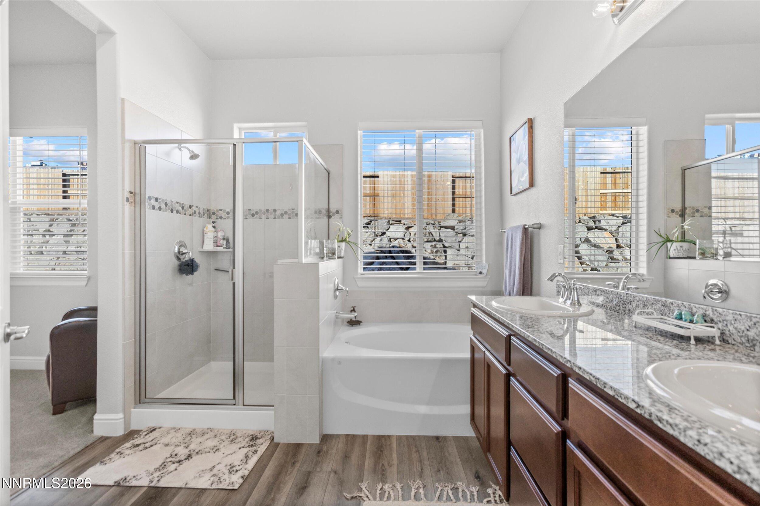 11125 Gallaudet Drive Reno, NV 89506 - Photo 18 of 32 a bathroom with a granite countertop sink a mirror a bathtub and shower