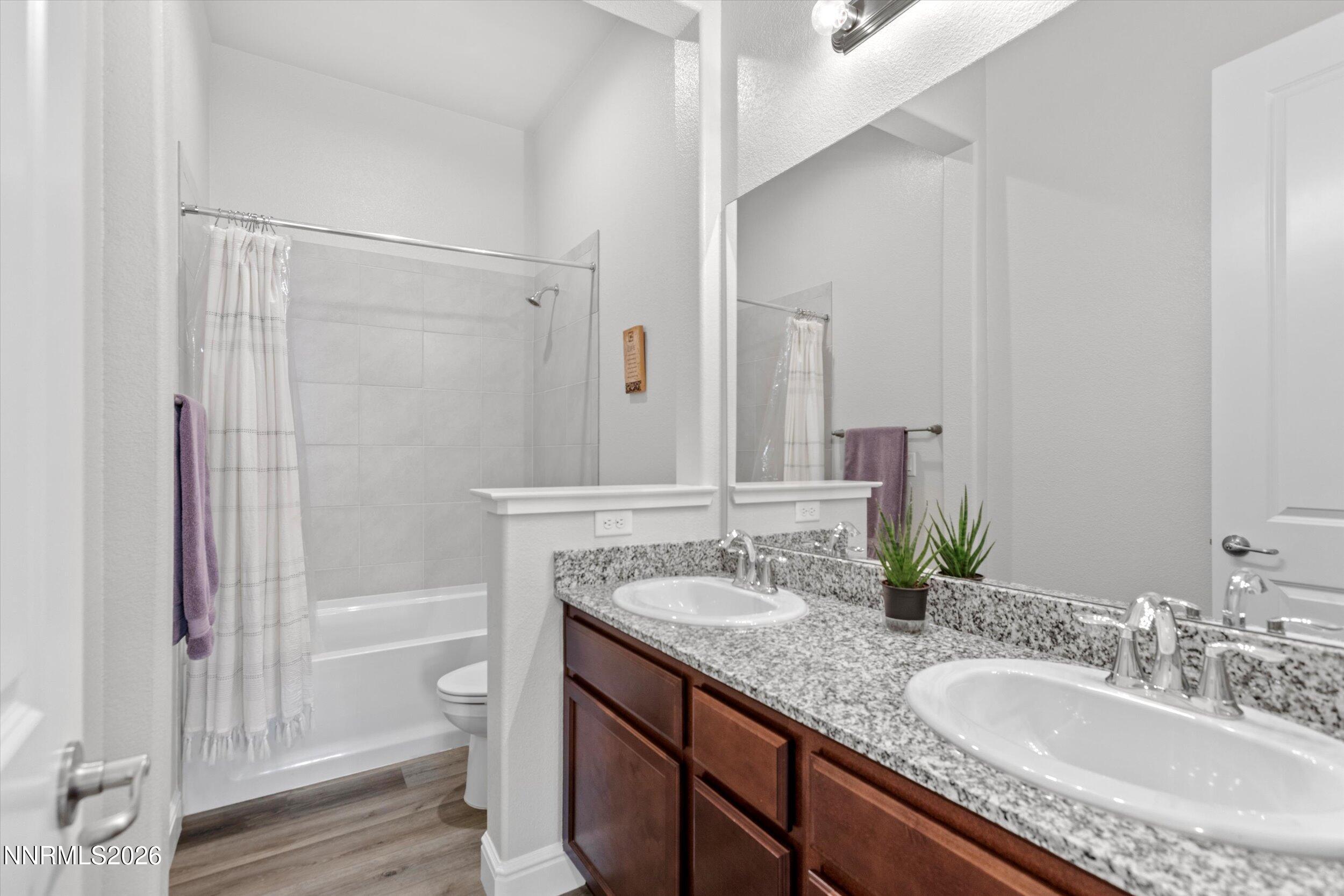 11125 Gallaudet Drive Reno, NV 89506 - Photo 20 of 32 a bathroom with a granite countertop sink a mirror and a bathtub