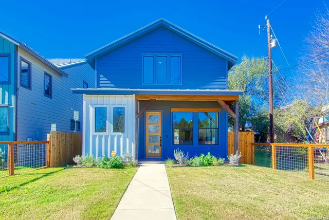 a view of a house with a yard and potted plants