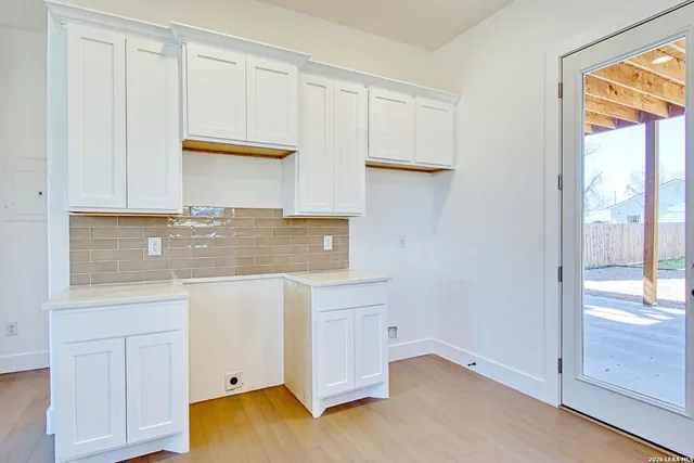 a kitchen with stainless steel appliances granite countertop a sink window and cabinets