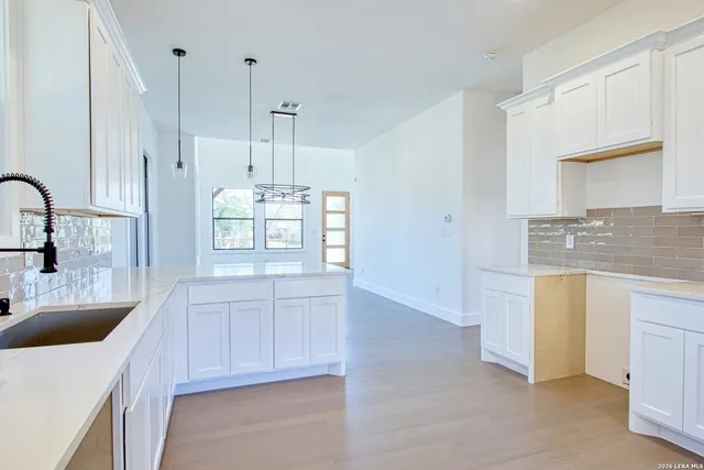 a kitchen with kitchen island white cabinets and sink
