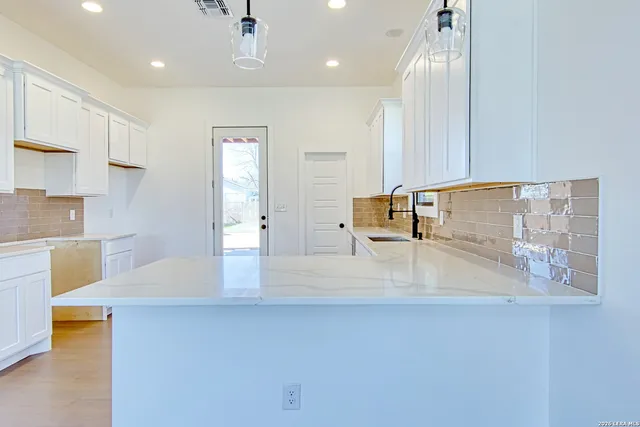 a large white kitchen with wooden floors