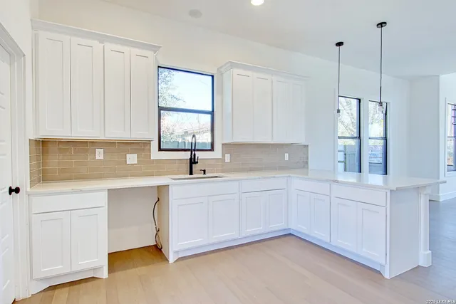 a kitchen with white cabinets and a sink