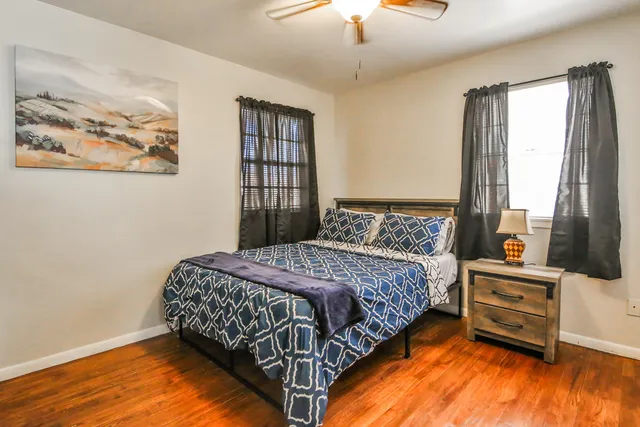 a bedroom with a bed dresser and window