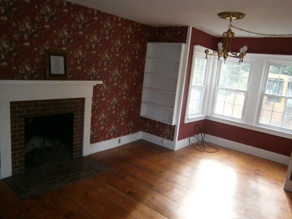 125 West Main Street Rindge, NH 03461 - Photo 8 of 19 a view of an empty room with wooden floor and a fireplace