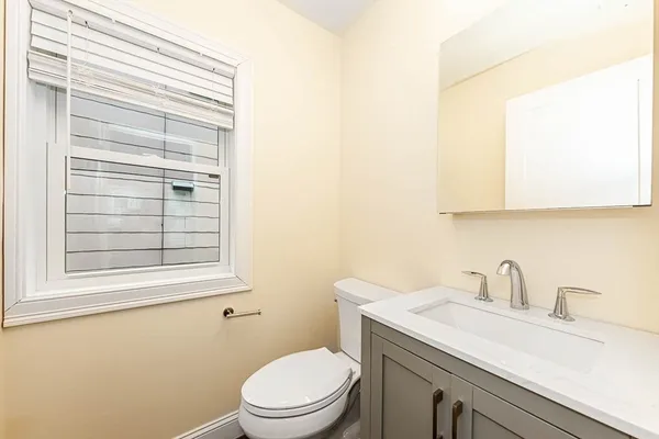a bathroom with a sink a toilet and a window