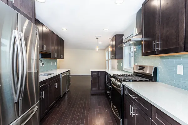 a kitchen with stainless steel appliances sink stove microwave and cabinets