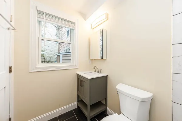 a bathroom with a toilet a sink and a window