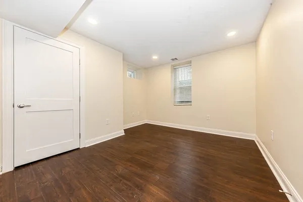 an empty room with wooden floor and white walls