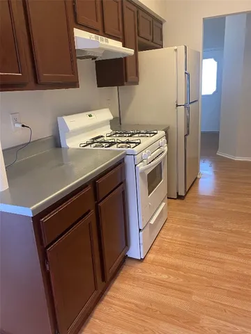 a kitchen with stainless steel appliances granite countertop a sink a stove a refrigerator and cabinets