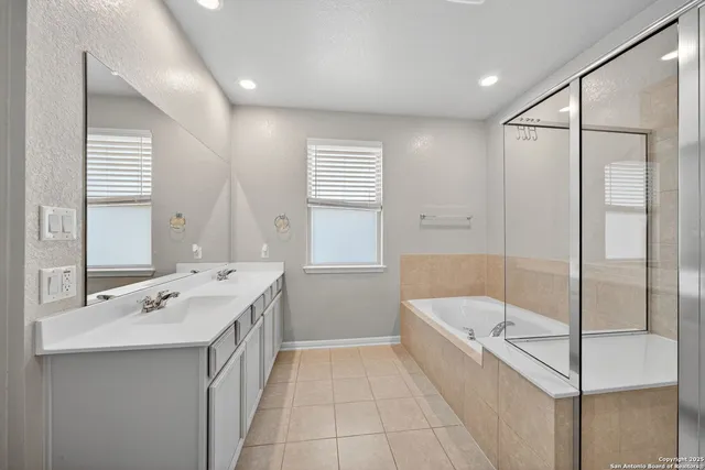 a bathroom with a tub sink and mirror