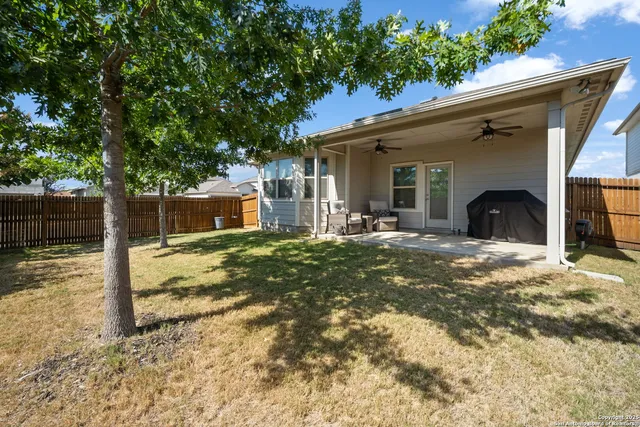 a view of a house with backyard and tree