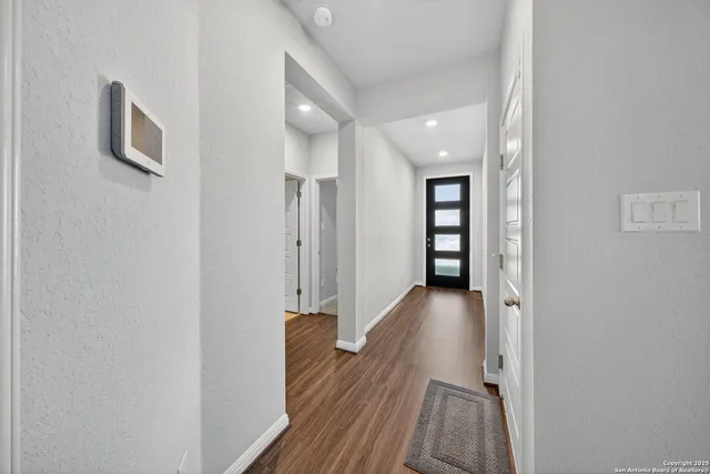 a view of a hallway with wooden floor and staircase