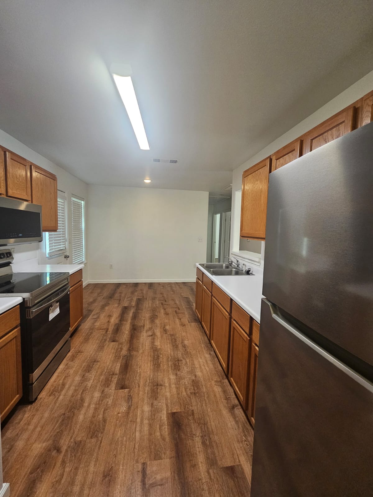 606 Trinity Street Lockhart, TX 78644 - Photo 8 of 23 Sleek stainless steel appliances complement the warm wood cabinetry in this well-appointed kitchen.