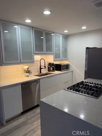a kitchen with granite countertop a sink and a stove top oven