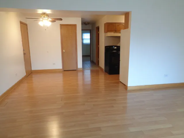 a view of an empty room with closet and a bathroom