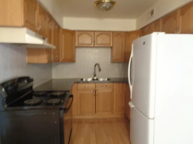 a kitchen with a sink a refrigerator and cabinets