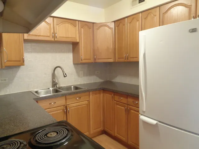 a kitchen with a refrigerator and a stove top oven