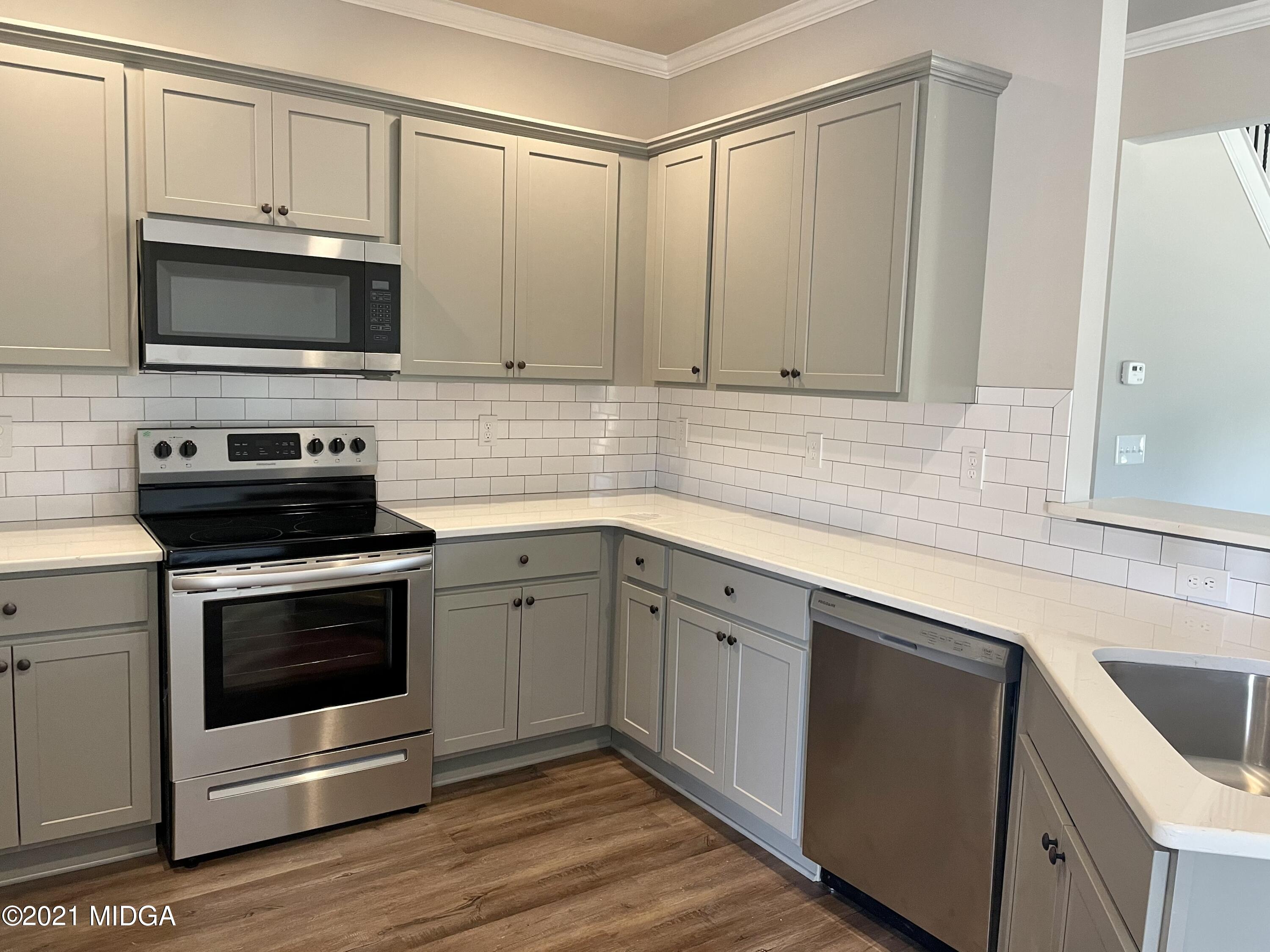 1452 Bunn Road Forsyth, GA 31029 - Photo 5 of 9 a kitchen with white cabinets stainless steel appliances and sink
