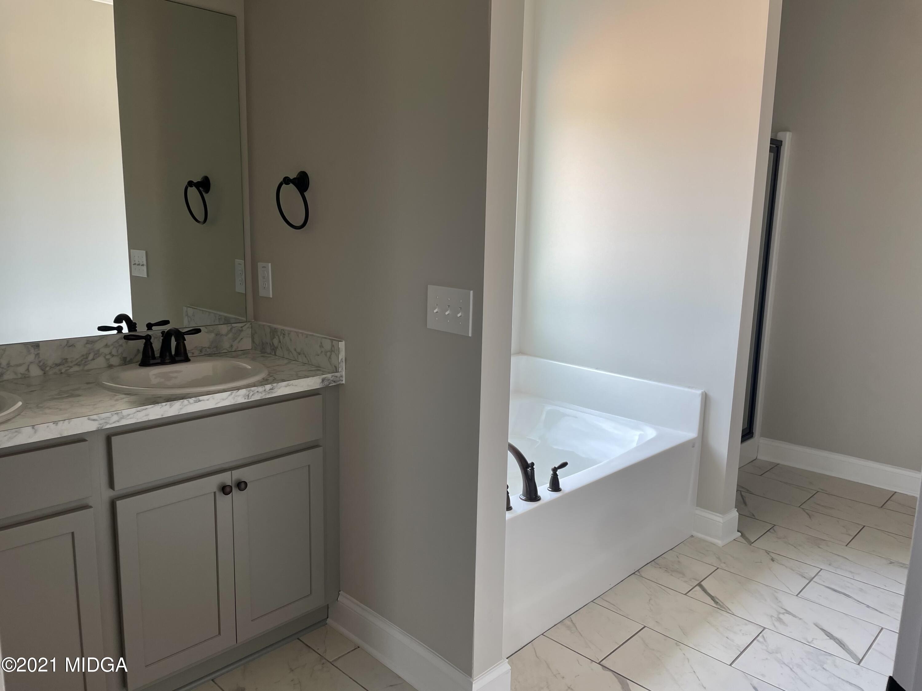 1452 Bunn Road Forsyth, GA 31029 - Photo 8 of 9 a bathroom with a tub sink and vanity