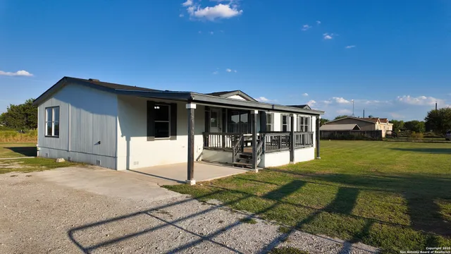 a view of a house with backyard and sitting area