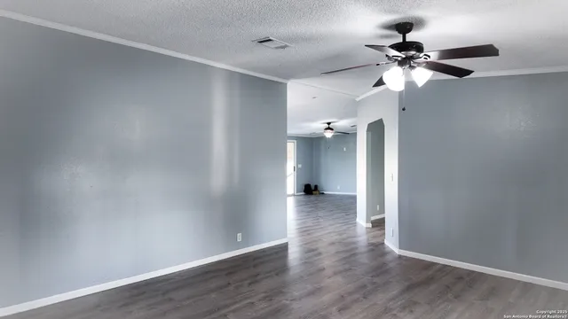 wooden floor in an empty room with a fan