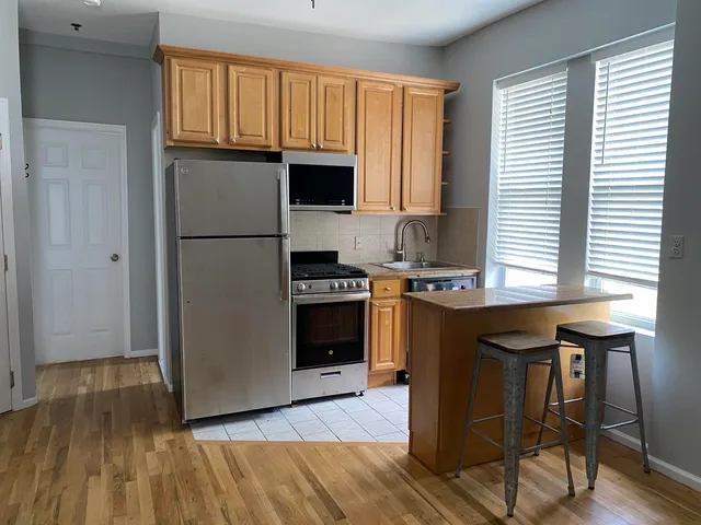a kitchen with granite countertop wooden floors and white stainless steel appliances