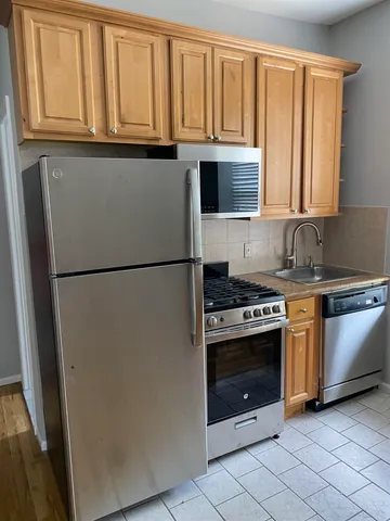 a kitchen with granite countertop a refrigerator and a sink