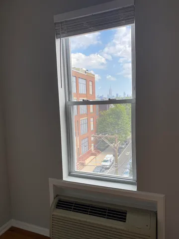 a view of a room that has a large window and front door