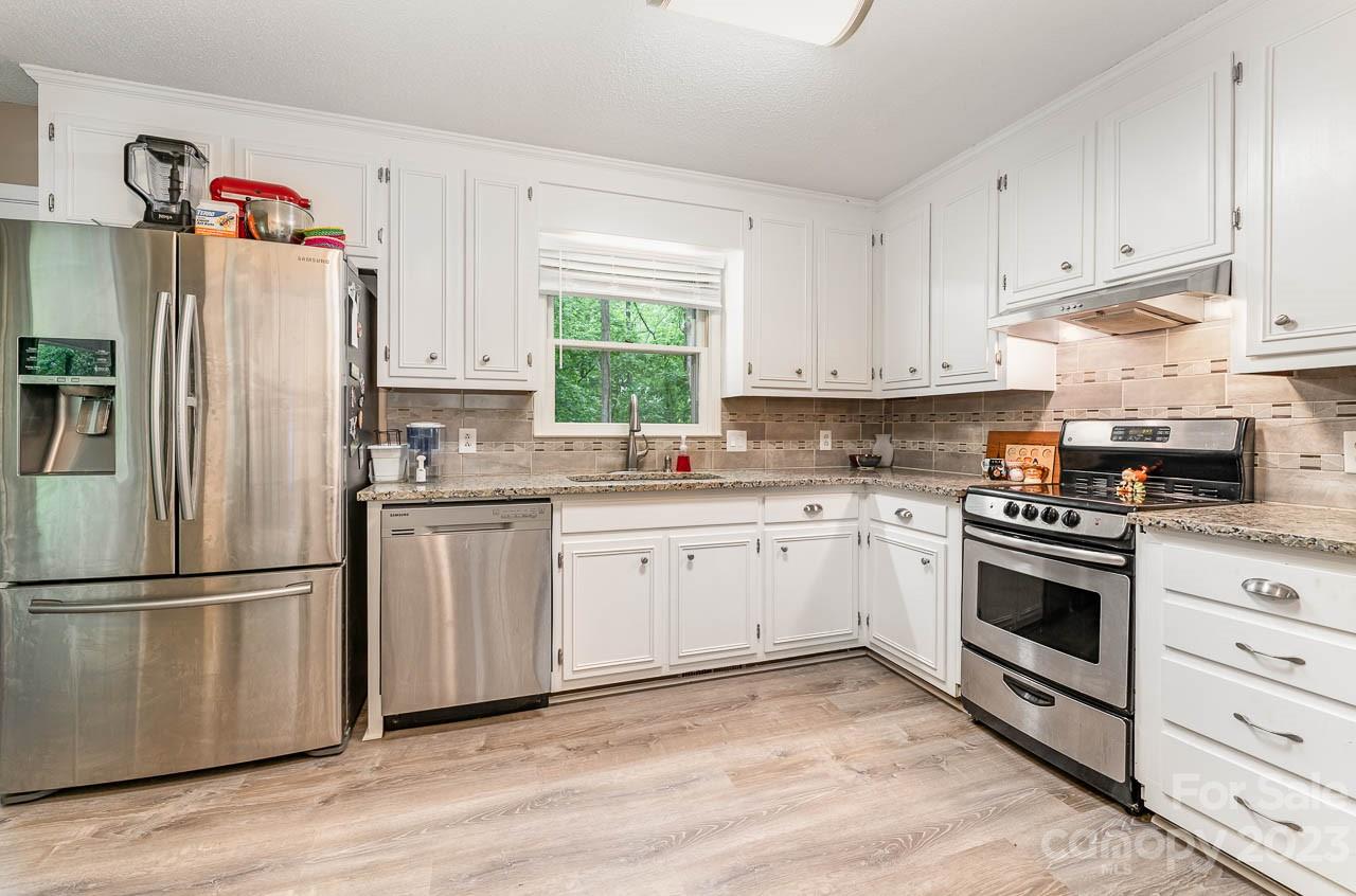 240 Hidden Hut Road Salisbury, NC 28147 - Photo 15 of 32 a kitchen with granite countertop white cabinets and white appliances