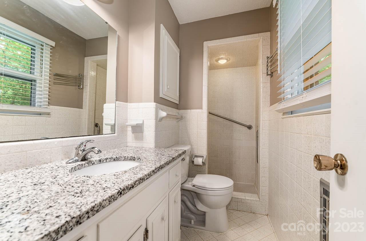 240 Hidden Hut Road Salisbury, NC 28147 - Photo 22 of 32 a bathroom with a granite countertop sink a toilet and shower