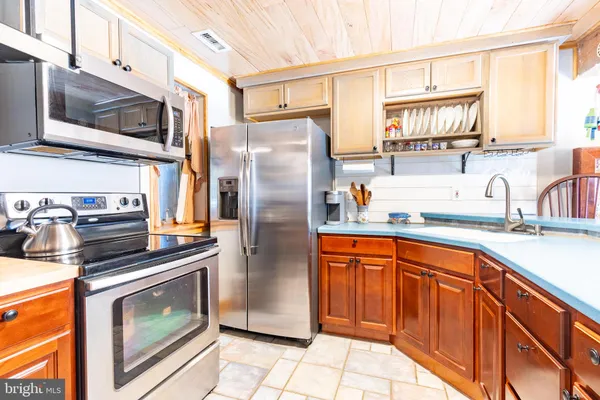 a kitchen with stainless steel appliances granite countertop a refrigerator stove and sink