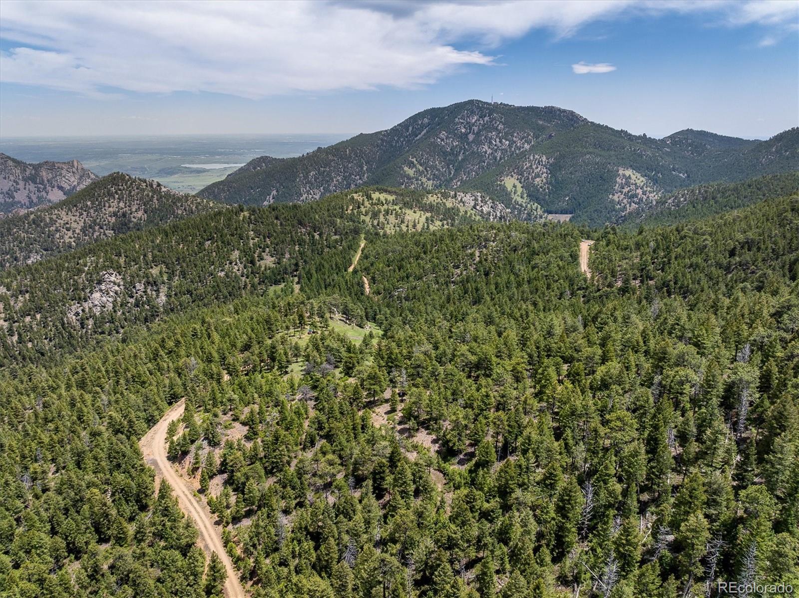 1259 Chute Road Golden, CO 80403 - Photo 14 of 21 a view of a mountain range with lush green forest