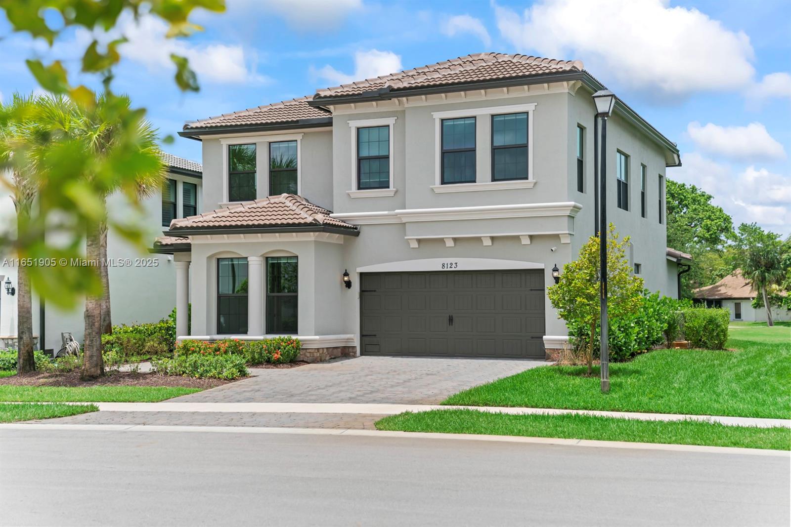 a front view of a house with a yard and trees