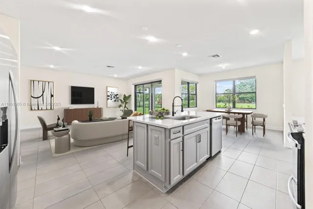 a large white kitchen with a large window and couch