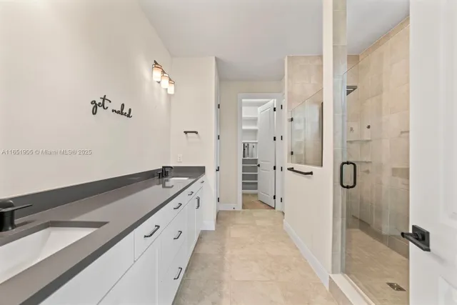 a spacious bathroom with a granite countertop sink mirror and shower