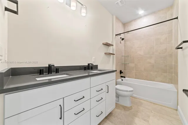 a bathroom with a double vanity sink toilet mirror and shower