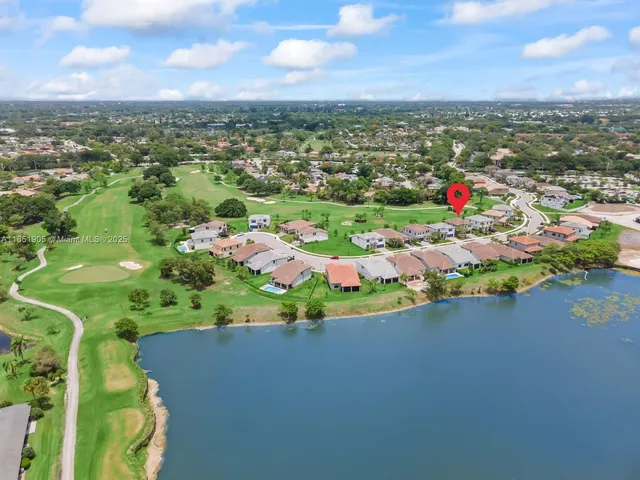 an aerial view of residential houses with outdoor space and trees