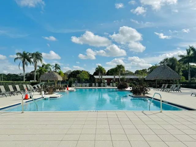 a view of a swimming pool and lounge chairs in patio