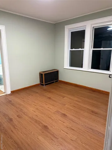 a big room with wooden floor and windows