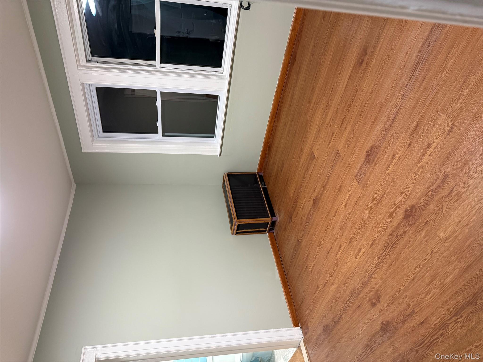 127-05 88th Avenue Queens, NY 11418 - Photo 5 of 9 a big room with wooden floor and windows