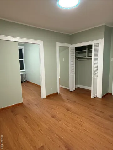 an empty room with closet and wooden floor