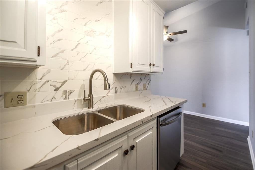 2529 Rio Grande Street, Unit 93 Austin, TX 78705 - Photo 4 of 19 The kitchen features a stainless steel double sink with a modern faucet, white cabinetry, and white countertops with grey veining