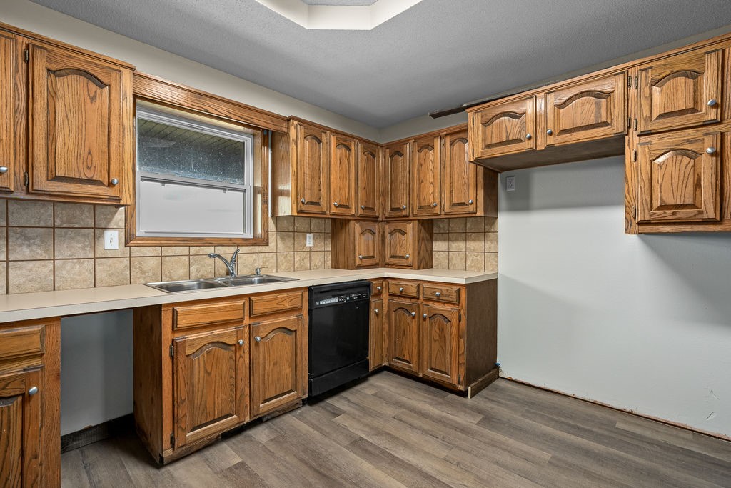 3022 Dow Jones Road Alma, AR 72921 - Photo 11 of 34 Kitchen featuring brown cabinetry, light countertops, and dishwasher